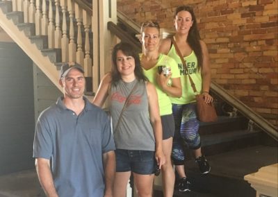 4 scavenger hunt team members stand near a staircase.