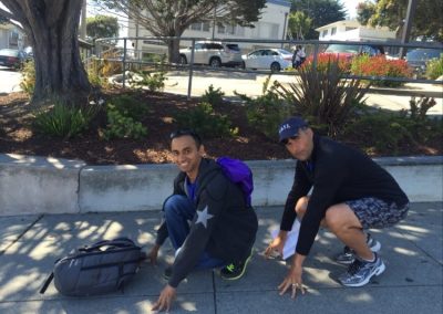 Team members sit in a frog position during a team building activity in Monterey.