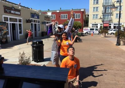 Team members standing in one line during a team building activity in Monterey.