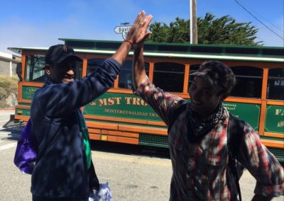 Scavenger hunt team members hi-5 in front of a tram