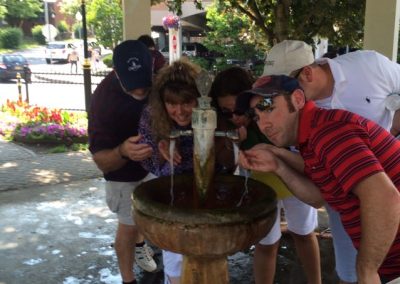 Scavenger hunt team members drinking water from a fountain