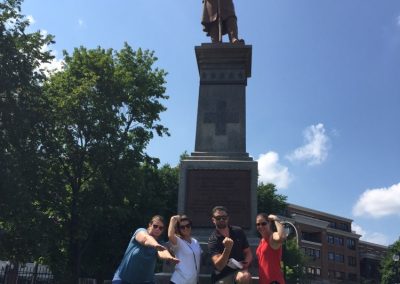 Team members standing in front of a statue during a team building activity in Saratoga Springs.