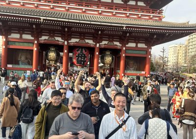 Team members take a photo in front of a Japanese temple