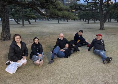 Team of 6 sitting on a lawn during a team building activity in Ginza, Tokyo.