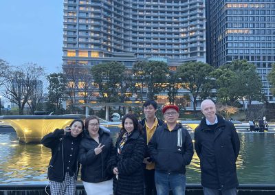 Scavenger hunt team stands in front of giant buildings.