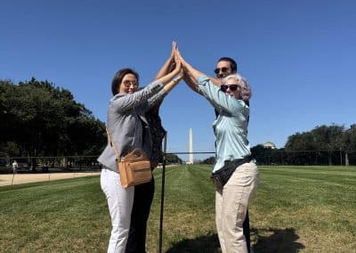 4 team mebers form a pyramid in front of an obelisk in Washington DC