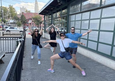 4 team members doing silly poses during a team building activity in Kansas City River Market